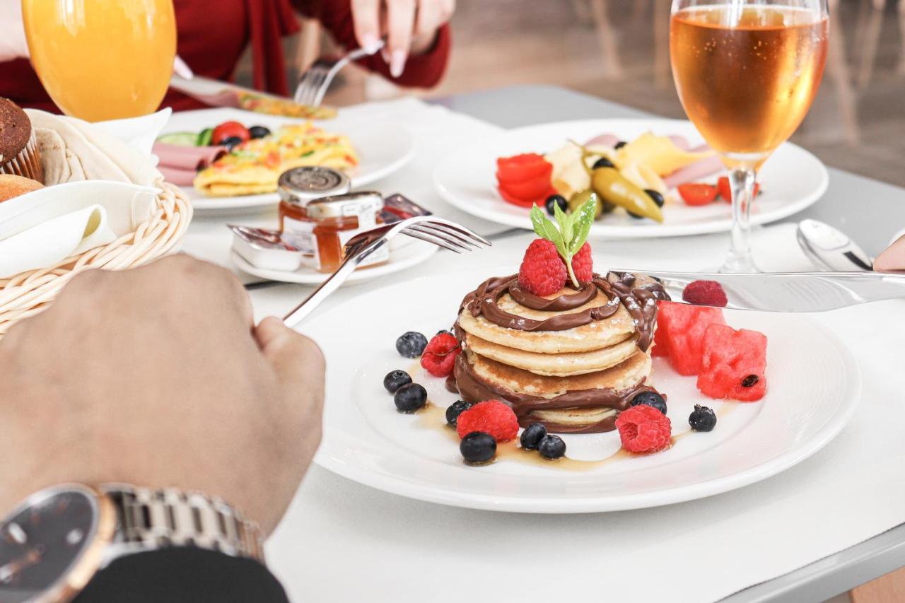 The Bentley Luxury Hotel & Suites Doha Exteriör bild A stack of pancakes with fruit
