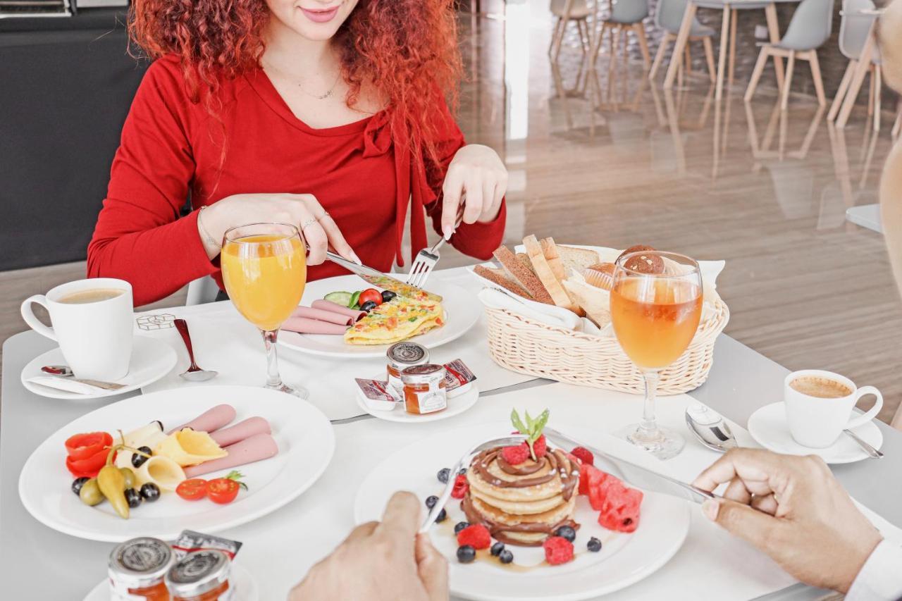 The Bentley Luxury Hotel & Suites Doha Exteriör bild A woman eating breakfast