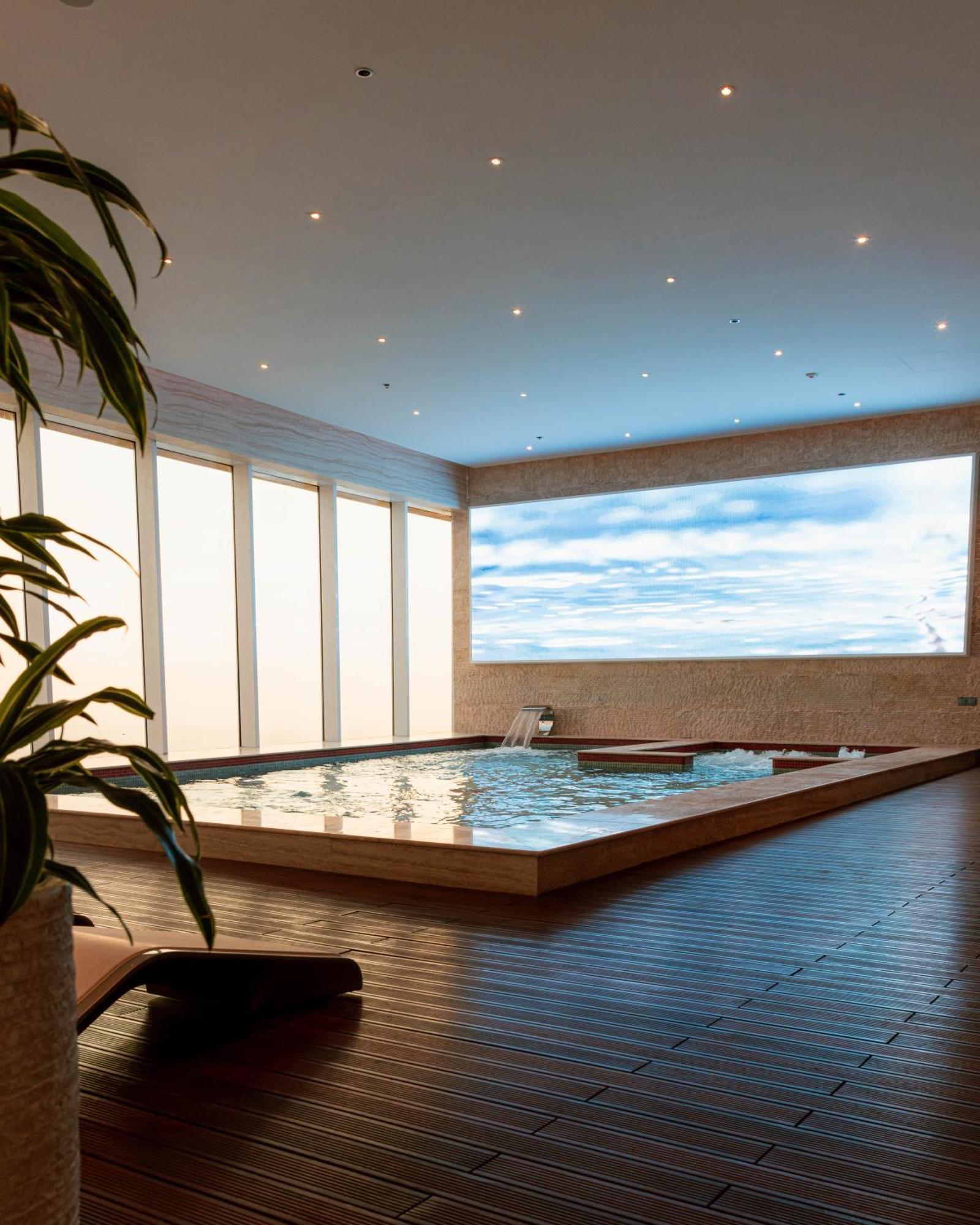 The Bentley Luxury Hotel & Suites Doha Exteriör bild A swimming pool with a translucent ceiling